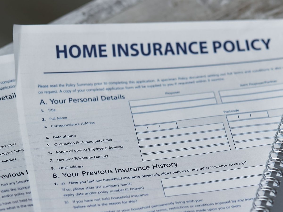 A printed home insurance policy form lying on a desk, ready to be completed