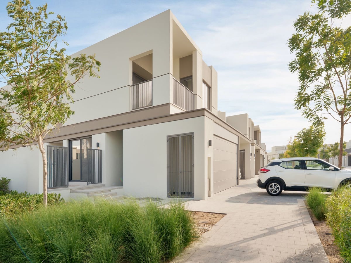 A modern two-storey villa in a green residential community in Dubai, on a clear day
